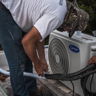 Un technicien règle une unité de climatisation extérieure