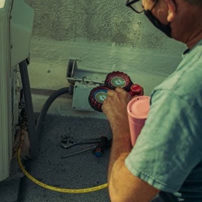 Un artisan sur une échelle, ceinture d’outils à la taille